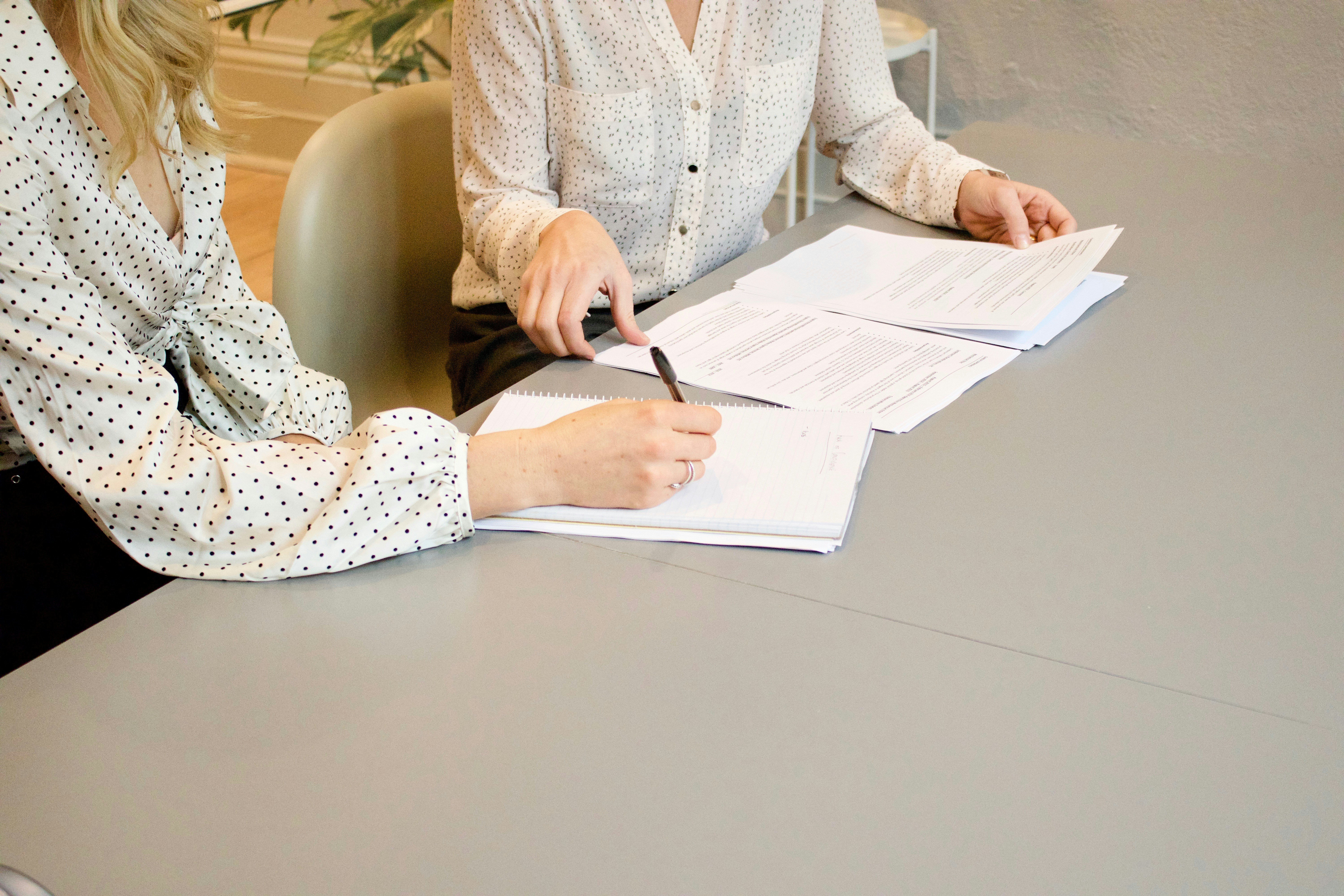 A person taking handwritten notes on a clipboard after a roadway incident